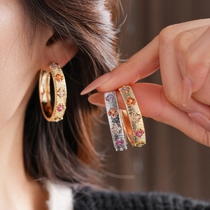 Gros plan détaillé des boucles d'oreilles créoles dorées 18K avec zircons multicolores