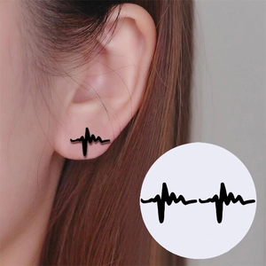 Close-up of minimalist black heartbeat waveform ear studs shown on ear and as a pair