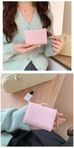 Dettaglio del portafoglio rosa a righe con nappina abbinata e fessure per carte di credito