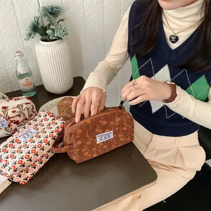 Détail de la trousse de toilette en velours côtelé fleuri avec fermeture éclair