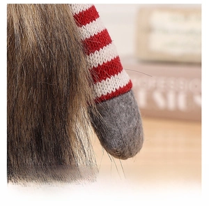 Detail of knitted red sleeve and felt hand on Christmas gnome wine bottle cover