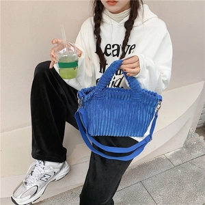 Détail du sac cabas en velours côtelé bleu montrant le tissu et la bandoulière