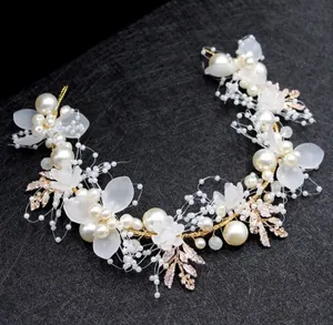 Detail of bridal hair vine with white pearls, frosted petals and golden alloy leaves