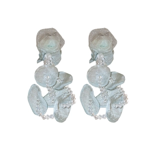 Boucles d'oreilles élégantes en tulle vert clair avec cristaux sur fond blanc