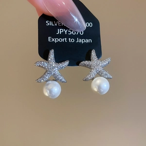 Détails de boucles d'oreilles étoile en zircons avec perles blanches élégantes