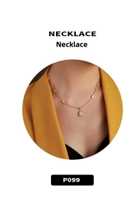 Detail shot of a minimalist gold necklace featuring a round double-ring shell pendant