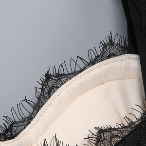 Detail of black eyelash lace stitching with champagne satin lining on fishtail dress