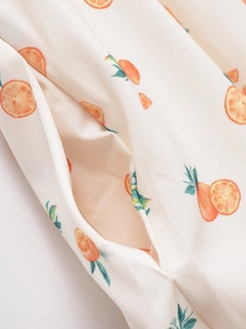 Détail de la couture de poche sur une robe tissée avec motif d'imprimé orange