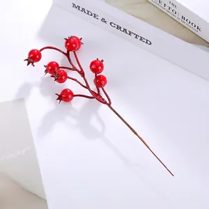 Detailed view of glossy red artificial berries on branches for home and festive decor