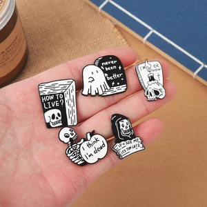 Set of 5 black and white gothic skull and ghost enamel pins on natural linen background