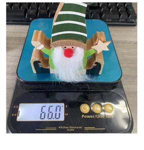 Detailed weight measurement of a Christmas gnome wooden figurine on a digital kitchen scale