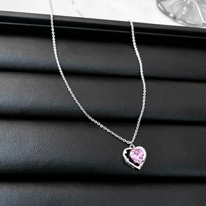 Detail of pink heart zircon necklace with silver hollow frame on black leather