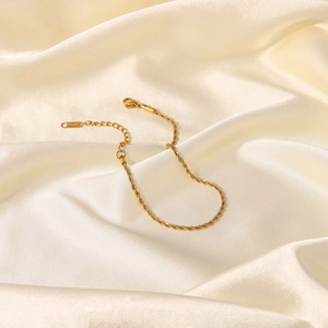 Elegant 2mm gold titanium steel twisted rope anklet for women on white silk background