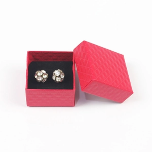 Close-up of sparkling disco ball stud earrings inside a red quilted jewelry gift box