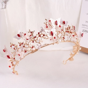 Detailed view of golden butterfly bridal crown with red rhinestones and white flowers