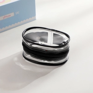Detail of oval transparent PVC storage bag with black zipper for doll display