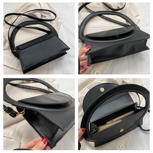 Detailsicht der schwarzen strukturierten PU-Handtasche mit Rundgriff und Magnetverschluss