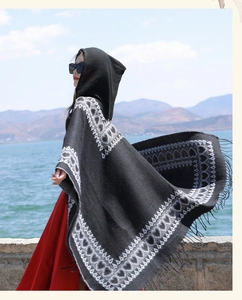 Outdoor view of an ethnic hooded shawl with heart pattern and elegant fringe details.