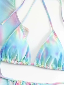 Detail van driehoekige bikinitop met kleurrijke tie-dye print en geplooide textuurdetails