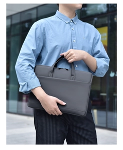 Slim dark grey 14-inch laptop briefcase shown with a professional business casual outfit