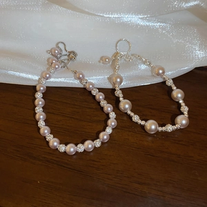 Détail de bracelets en perles roses avec perles scintillantes et chaînes réglables