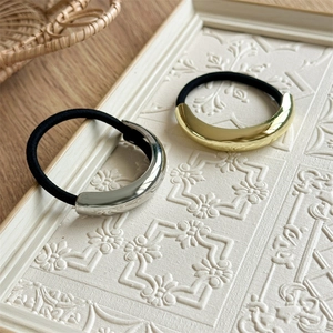 Close-up of gold and silver metallic curved charms on high-elasticity hair ties