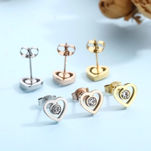 Detailed view of heart-shaped stud earrings in silver, rose gold and gold with crystals