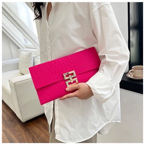 Detail of fuchsia crocodile embossed envelope clutch with large square gold metal clasp
