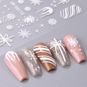 5D Christmas nail stickers with white embossed snowflakes and bows on pink manicured nails