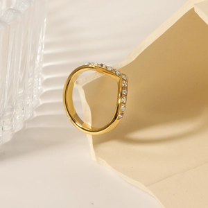 Elegant gold V-shaped ring for women with inlaid zircons on a creative minimalist display