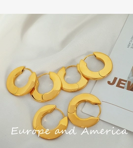 Close-up of five chunky 18k gold plated hoop earrings with high-polish metallic finish