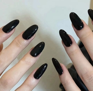 Detailed close-up of glossy deep black almond-shaped press-on nails with mirror finish