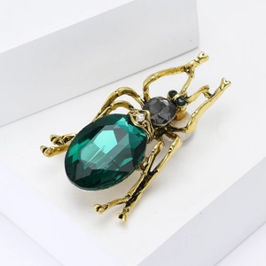 Retro beetle brooch with emerald gemstone and crystals on golden metallic base