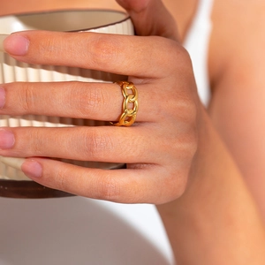 Polished 18k gold plated stainless steel curb chain ring worn on a lifestyle setting