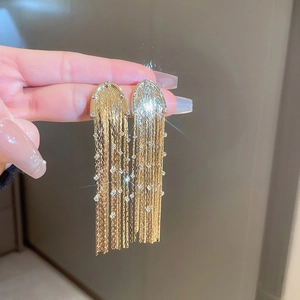 Elegant gold tassel earrings with shimmering white crystals in a long dangle style
