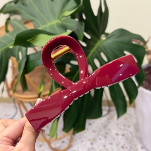 Detail of burgundy bow hair claw with strong gold spring for thick hair styling