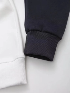 Macro view of ribbed cuffs and two-tone stitching on navy and white sweatshirt