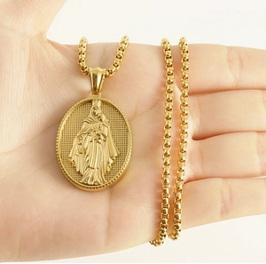 Dettaglio del rilievo della Vergine Maria su ciondolo ovale dorato in mano