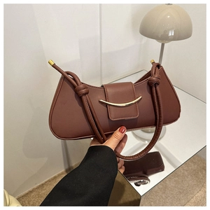 Detailed view of dark brown crescent underarm bag with gold buckle and twisted handle
