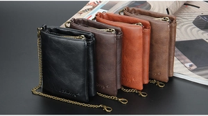 Short vintage leather wallets for men with metal chains in four colors on a dark magazine