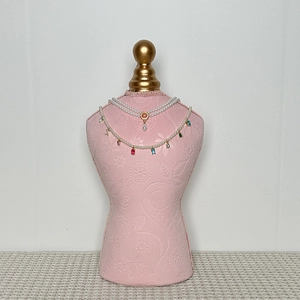 Detail of layered pearl choker with pink gemstone and multicolored teardrop pendants