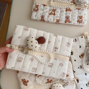 Detailed close-up of quilted cotton storage bag featuring bear prints and pearl handles