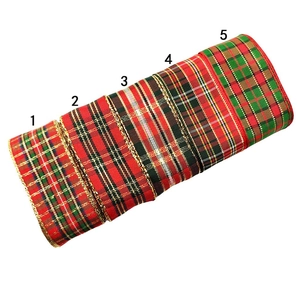 Detail of five plaid Christmas ribbons with metallic gold edges for gift wrapping DIY