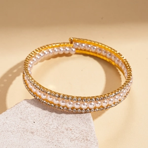 Detail of gold layered bracelet with pearls and rhinestones on a natural stone base