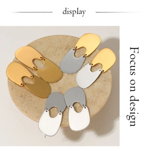 Close-up of geometric U-shaped earrings in polished gold and silver finishes