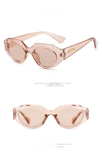 Detail view of tea-colored irregular geometric sunglasses with gold metal hinge accents