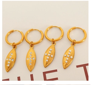 Detail of vintage gold earrings with crystal olive leaf and pearl pendant charms