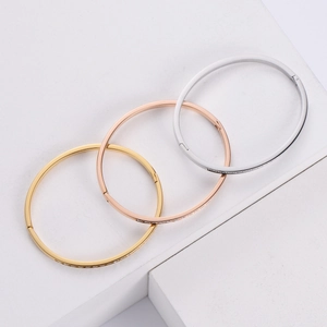 Set of minimalist bangle bracelets in gold, rose gold, and silver with inlaid cubic zirconia