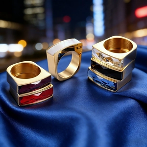 Macro detail of luxury square faceted glass gemstone rings in six colors on blue silk fabric