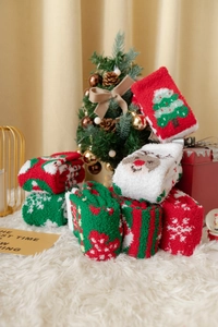 Festliche Korallenfleece Weihnachtssocken mit Rentier und Schneeflocken auf weißem Teppich